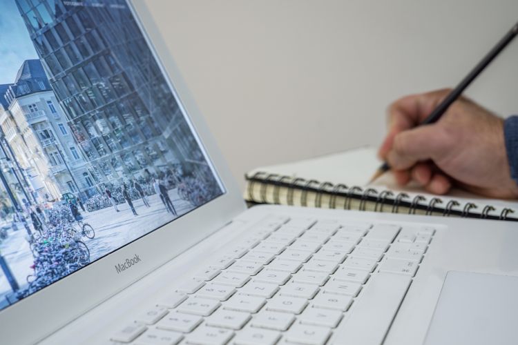 Hombre tomando apuntes de una computadora